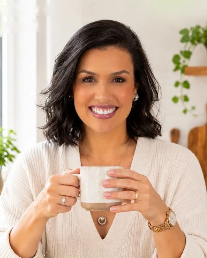 Cátia Guimarães, nutricionista, sorrindo com uma xícara na mão